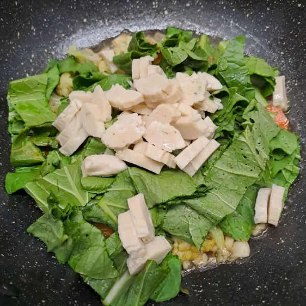 Masukkan fish roll dan caisim. Aduk rata, masak sampai matang. Angkat dan sajikan.