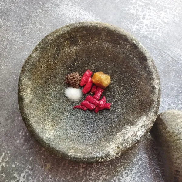 Masukkan bahan-bahan sambal (cabai rawit, cabai keriting, garam, terasi bakar, dan gula) kedalam cobek.