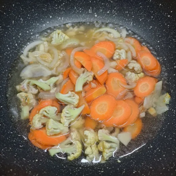 Masukkan wortel, bunga kol dan air. Masak sampai ½ matang.