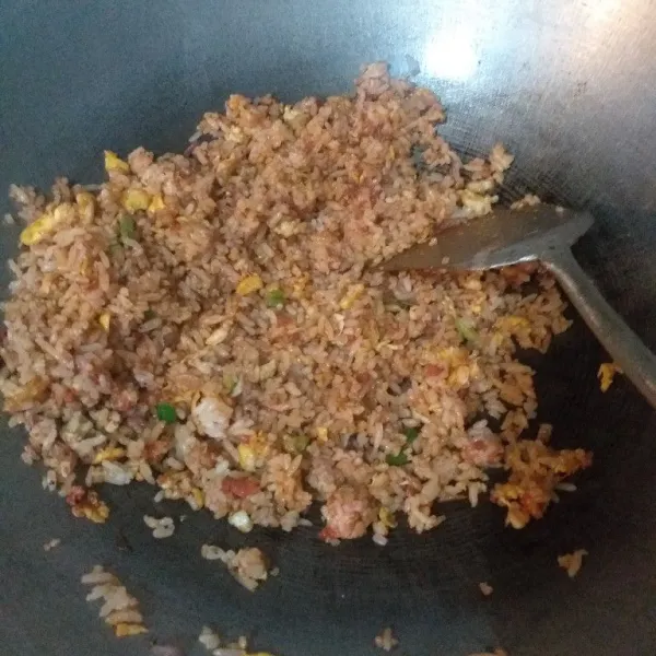Tambahkan nasi dan bumbu lainnya, aduk merata, tes rasa.