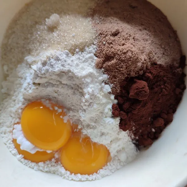 Campur jadi satu tepung terigu, susu bubuk, gula, coklat bubuk, vanilli , baking powder dan kuning telur.