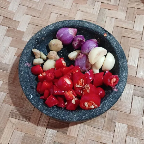 Haluskan bawang putih, bawang merah, cabai merah, dan kencur.