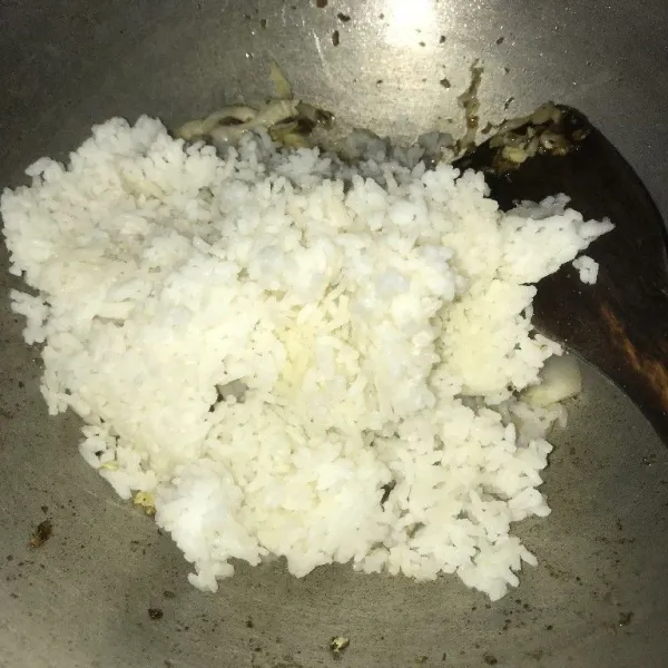 Masukkan nasi putih dan sayur kubis, aduk rata.