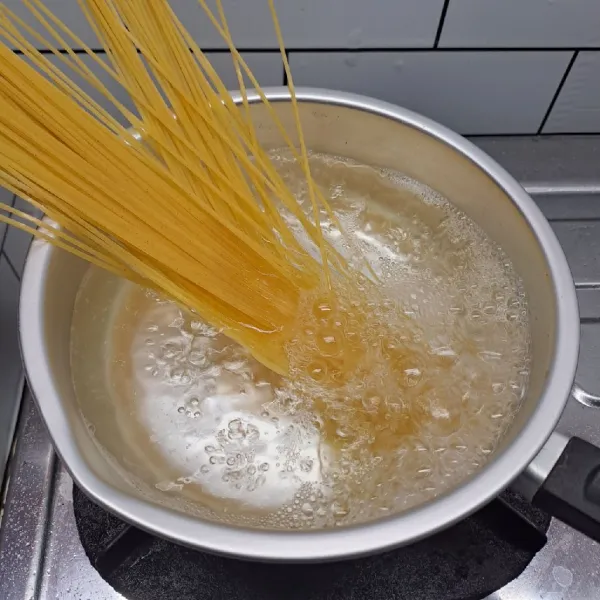 Rebus air sampai mendidih. Masukkan spaghetti, masak sampai matang, angkat dan tiriskan dengan sisa air rebusan sedikit (nyemek).