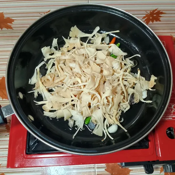 Kemudian masukkan jamur tiram, aduk rata dan masak hingga layu dan berair.