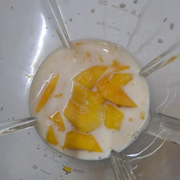 Blender mangga dengan 1 gelas susu UHT sampai halus.