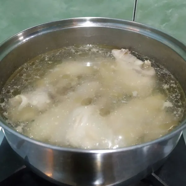 Masak 500 ml air hingga mendidih lalu rebus ayam selama 5 menit dengan api besar. Angkat dan tiriskan lalu sisihkan.