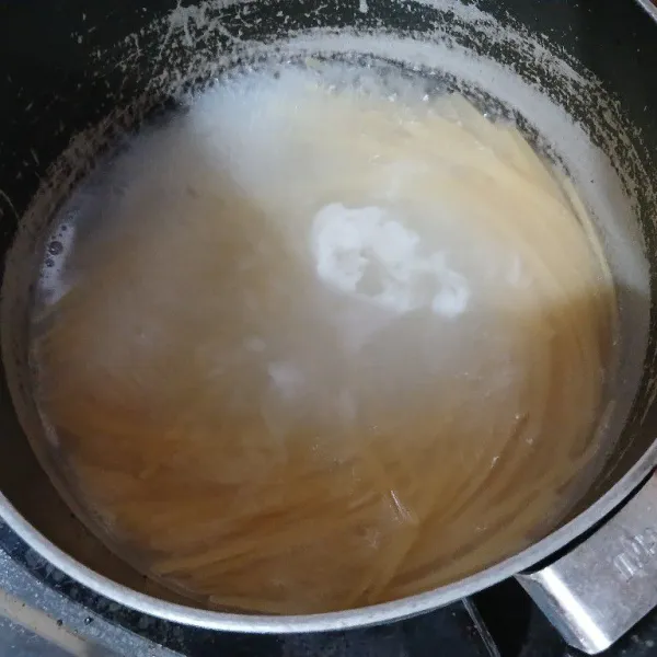 Didihkan air dengan sesendok minyak goreng. Masukkan spaghetti, beri sedikit garam. Rebus spaghetti hingga matang, angkat dan letakkan di piring saji. Sisihkan.