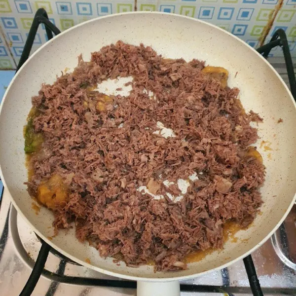 Masukkan daging yang sudah dihancurkan, aduk rata.