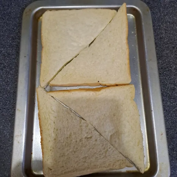 Potong roti tawar jd 2 bagian.