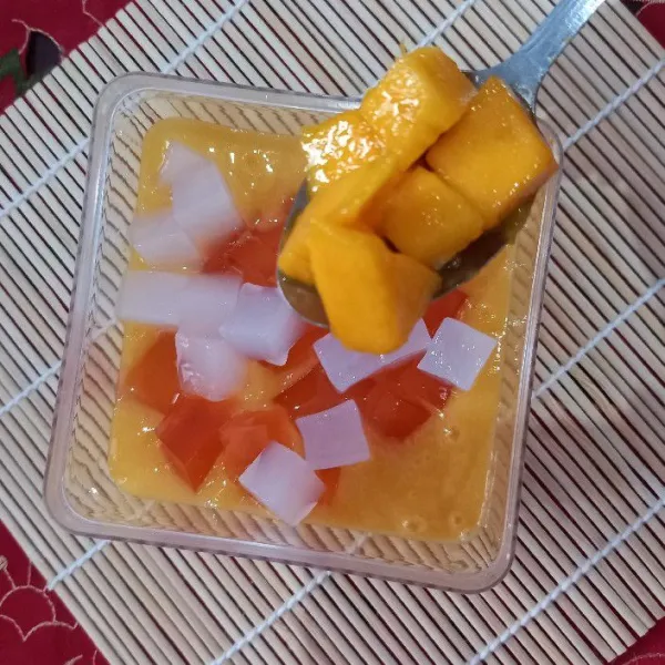 Tambahkan potongan jelly rasa mangga, nata de coco dan mangga.