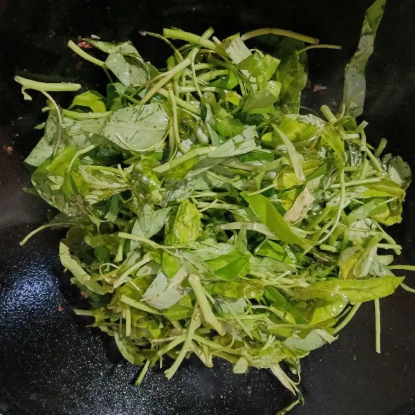 Masukkan kangkung, aduk rata. Masak hingga kangkung layu.
