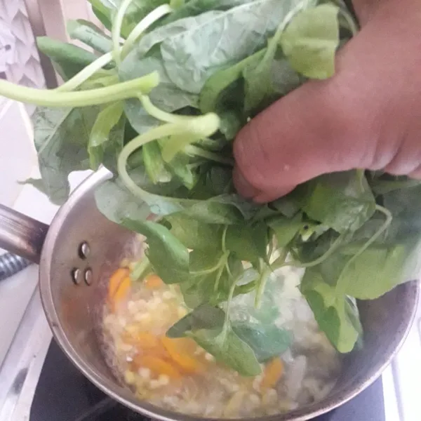 Masukkan bayam. Tambahkan garam, kaldu jamur, dan gula. Aduk dan rebus sebentar saja. Matikan kompor. Tambahkan bawang goreng, aduk kembali.