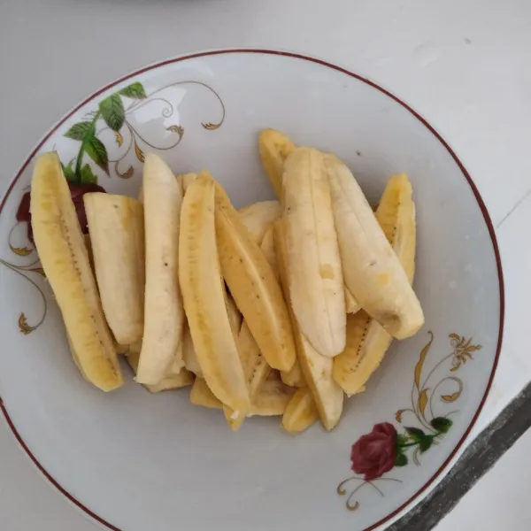 Kupas pisang dan potong menjadi 4 bagian memanjang.