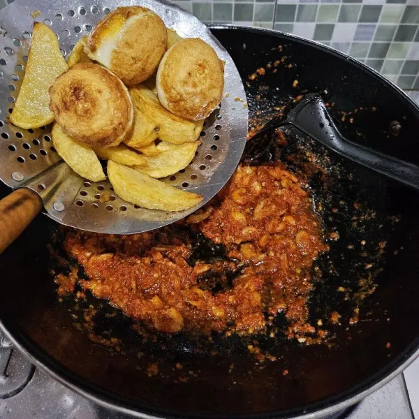 Masukkan kentang dan telur yang sudah digoreng.