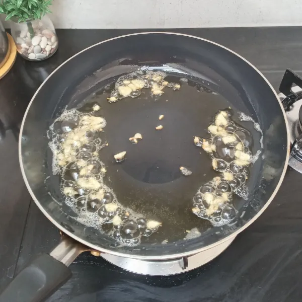 Panaskan 5 sdm minyak, tumis bawang putih hingga harum.