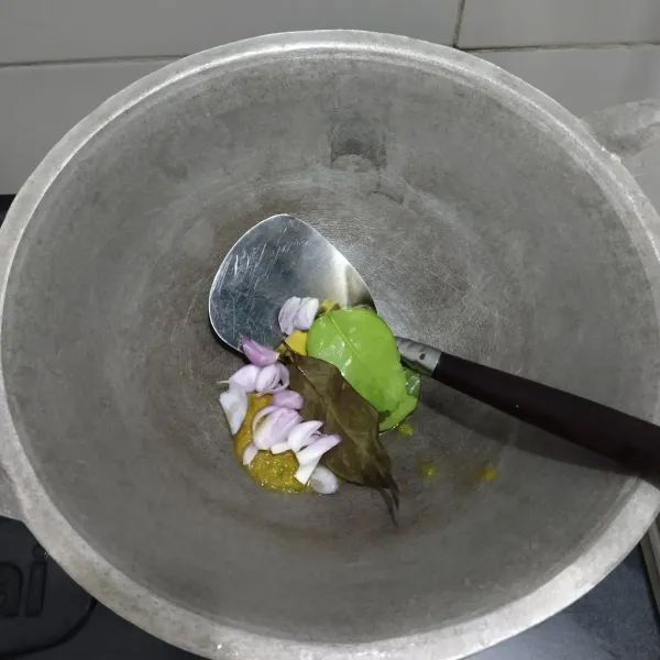 Masukkan bumbu halus, daun-daun (kecuali daun duku) dan bawang merah yang sudah diiris ke dalam wajan.