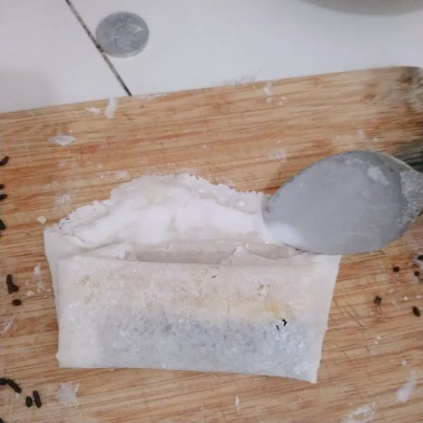 Olesi dengan larutan tepung terigu untuk merekat pada bagian lipatan terakhir.