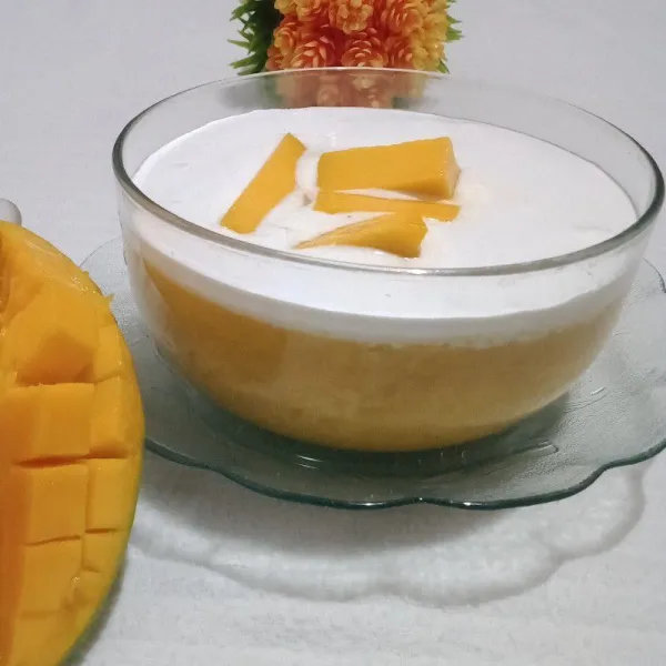 Tuang adonan puding di dalam mangkuk setelah agak set masukkan ke dalam kulkas hingga mengeras sajikan puding bersama whipping cream cair dan potong buah mangga di atasnya.