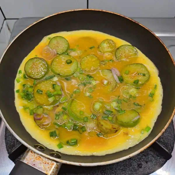 Tuang adonan telur, masak sampai bagian bawah berkulit. Balik omelette, masak sampai matang. Angkat dan sajikan.