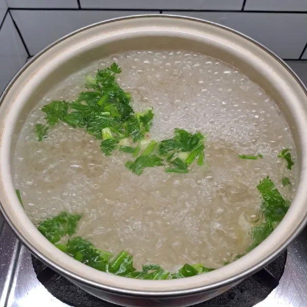 Rebus air, bawang putih cincang, irisan daun seledri dan daun bawang sampai mendidih.