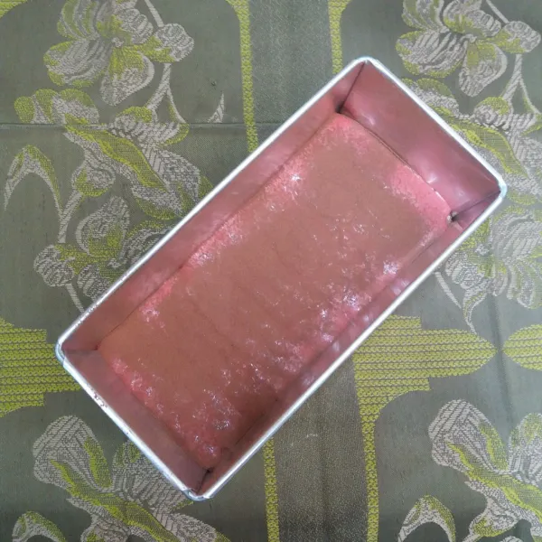 Tuang sebagian adonan warna ke loyang, taburi cokelat bubuk, tuang sisa adonan original, dan taburi cokelat bubuk.