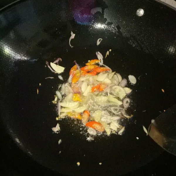 Siapkan pan dan panaskan minyak, tumis bawang merah dan bawang putih sampai harum. Kemudian masukan cabe rawit, aduk rata.