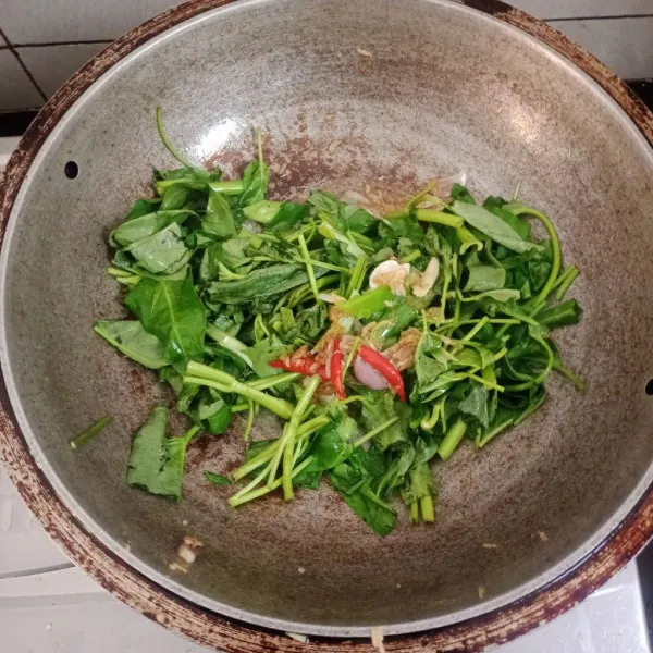 Iris kangkung, cuci. Masukan ke dalam tumisan bawang.