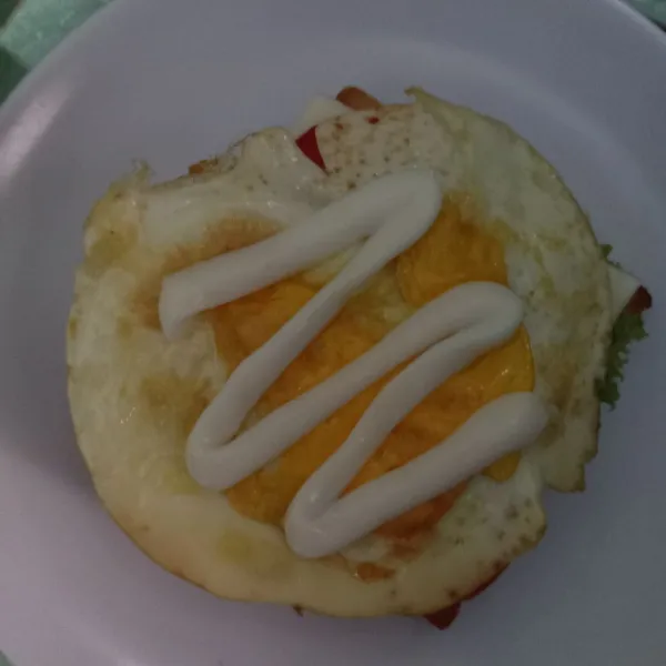 Beri tomat, telur ceplok dan mayonaise. Tutup dengan selembar roti tawar dan sajikan.