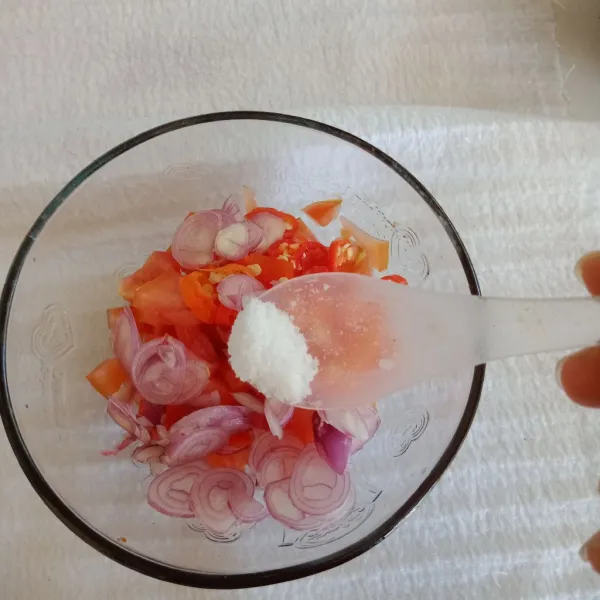 Siapkan mangkuk lalu masukkan irisan tomat, bawang merah, cabe rawit, dan garam.