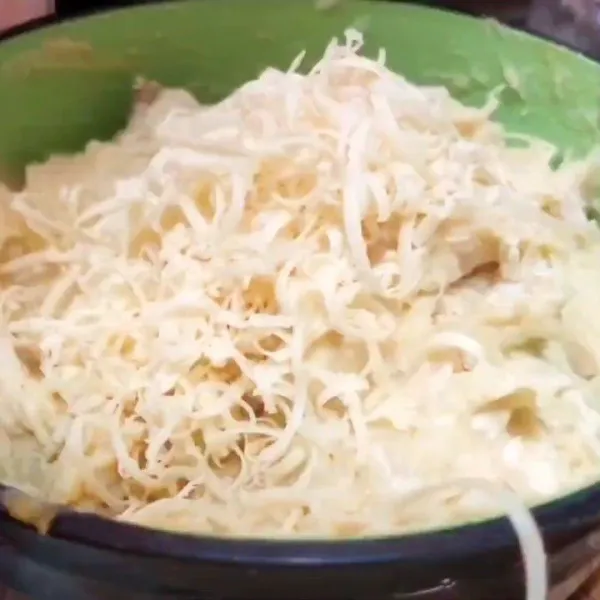 Masukkan ayam suwir yang sudah ditumis ke dalam kentang, tambahkan bumbu penyedap dan keju.