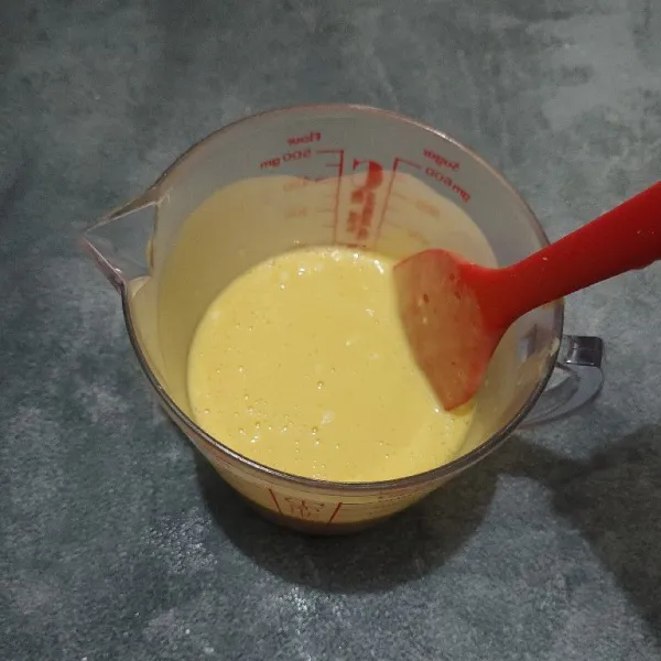 Tuang adonan ke dalam gelas takar, lalu aduk-aduk agar adonan tercampur dengan rata sampai tidak ada tepung yang bergerindil.