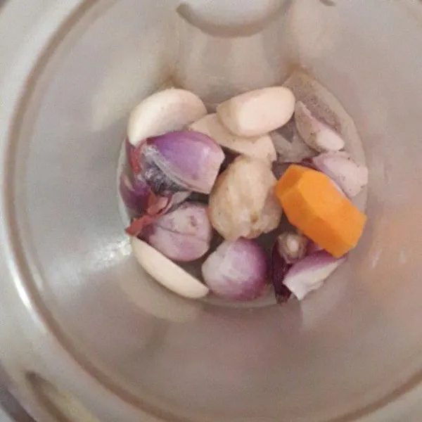 Siapkan blender. Masukkan bawang merah, bawang putih, kemiri, dan kunyit. Tambahkan sedikit air. Blender sampai halus.