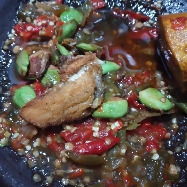 Goreng ikan asin hingga matang, tambahkan ke cobek, beri minyak sisa menggoreng ikan asin, ikan bisa disuwir terlebih dahulu setelah digoreng.