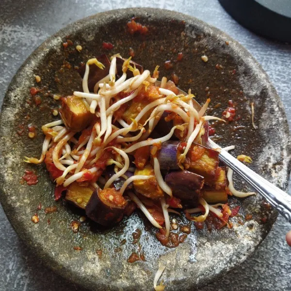 Masukkan tauge dan terong goreng ke dalam sambal lalu aduk rata.