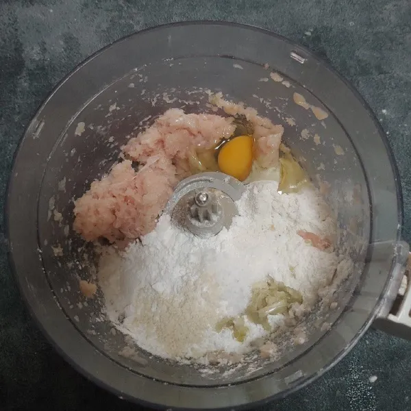 Masukkan telur, tepung tapioka, tepung terigu, bawang putih, garam, kaldu jamur, dan baking powder. Kemudian giling lagi hingga tercampur rata.