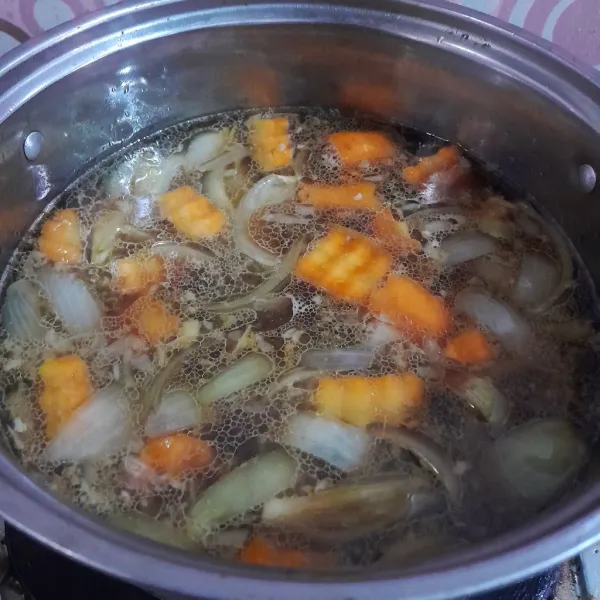 Tuangkan air mineral dan masak hingga kentang dan wortel setengah matang.