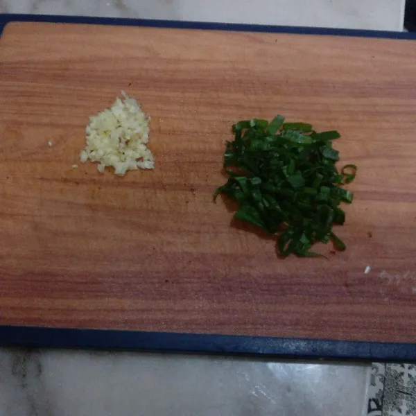 Cincang halus bawang putih dan iris daun bawang.