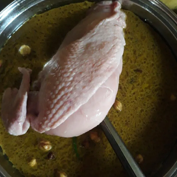 Masukkan ayam dan biarkan sampai ayam setengah matang. Angkat dan tiriskan ayam dari kuah santan.