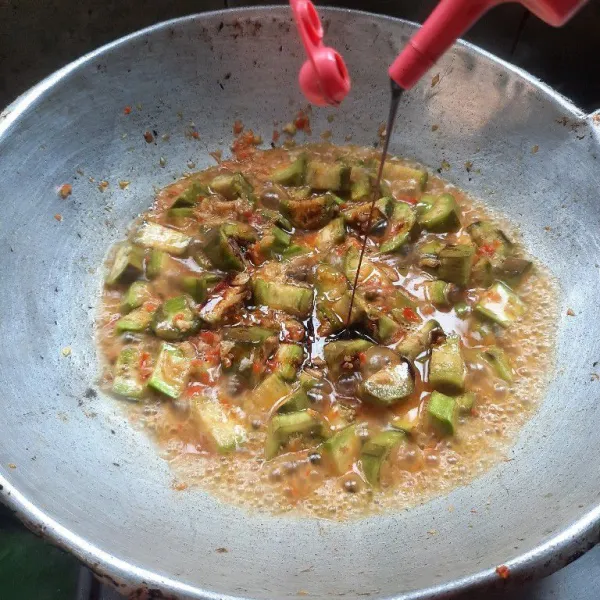 Tambahkan kecap manis, saus tiram, saus tomat, kaldu bubuk dan gula pasir. Aduk-aduk sampai terong benar-benar matang.