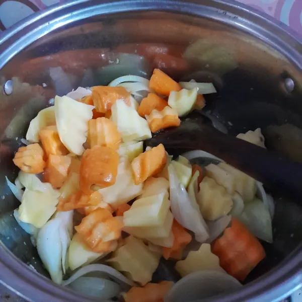 Tambahkan kentang dan wortel, aduk rata.