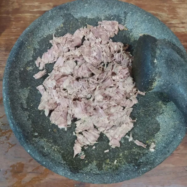 Getok daging rebus dengan ulekan. Suwir-suwir.