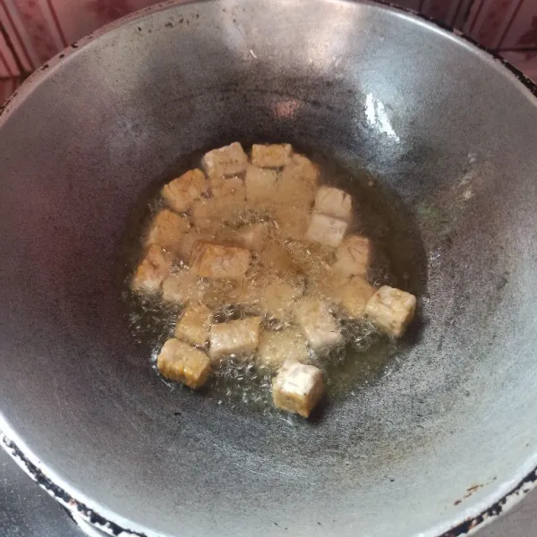 Potong dadu tempe kemudian goreng hingga setengah matang, setelah itu angkat dan tiriskan.