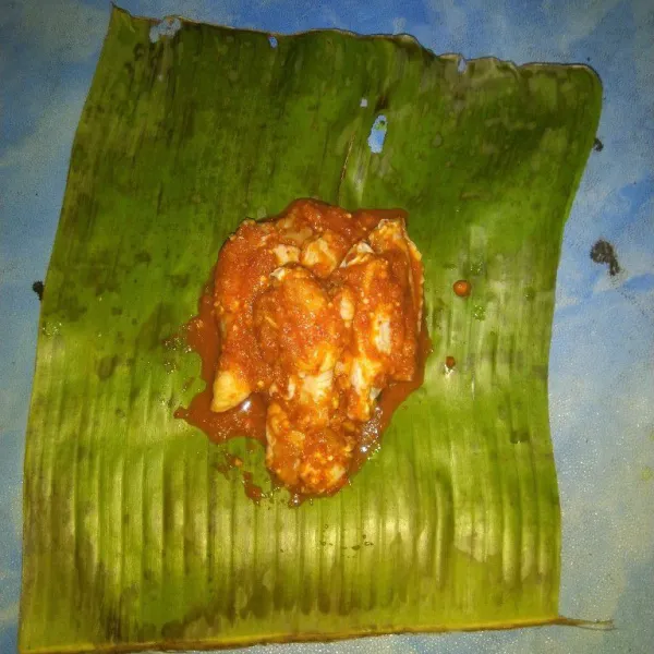 Siapkan secukupnya daun pisang, kemudian letakkan secukupnya sayap ayam yang sudah di bumbui kemudian gulung dan lipat ujungnya, bisa juga menyematkan lidi atau tusuk gigi pada kedua ujungnya supaya lebih rapi.