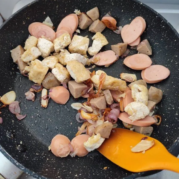 Kemudian masukkan potongan sosis, bakso dan tahu goreng. Tumis hingga sosis mengembang.
