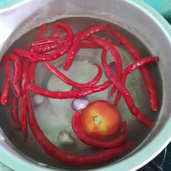 Rebus cabai merah, bawang merah, tomat, dan bawang putih sampai lunak.