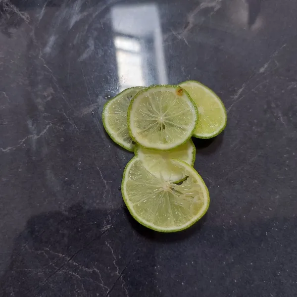 Potong-potong tipis 1 buah jeruk nipis, sisihkan.