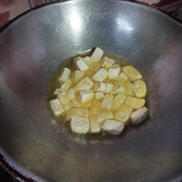 Potong dadu tahu kemudian goreng hingga setengah matang, setelah itu angkat dan tiriskan.