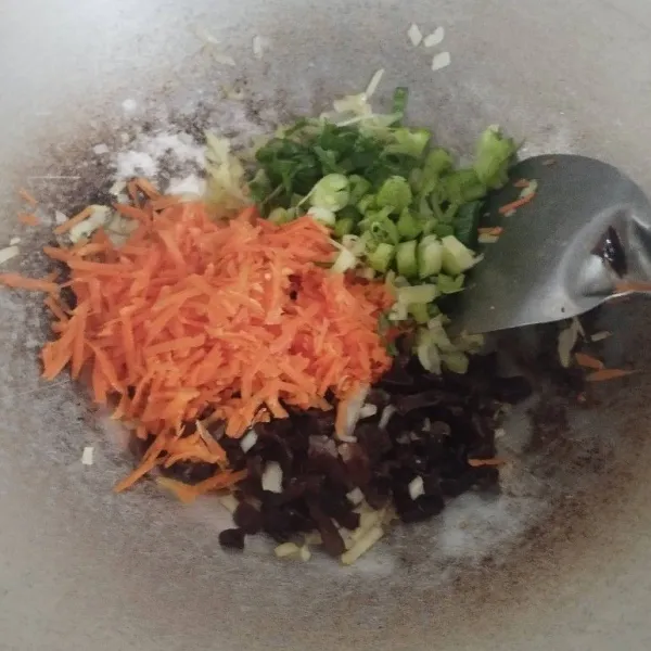 Masukkan wortel, jamur kuping daun bawang, aduk rata.