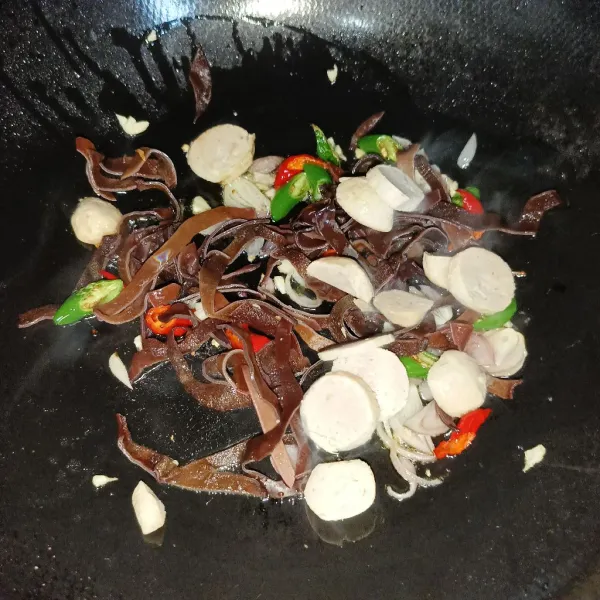 Masukkan jamur kuping dan irisan bakso, aduk rata.
